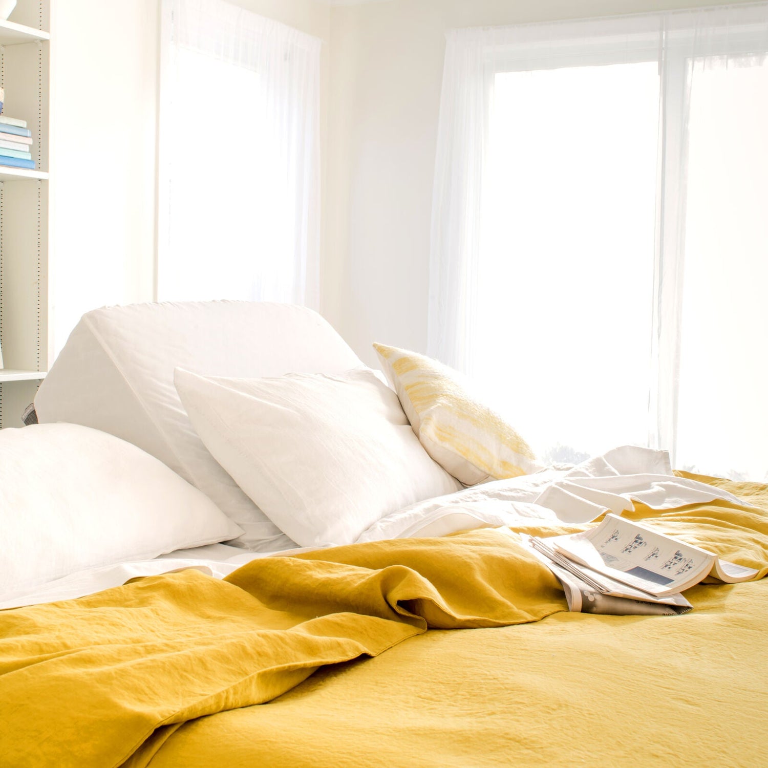 Sunlit bedroom with yellow duvet cover and soft sheets on an adjustable bed. 