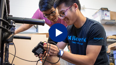 Two engineers reviewing the electronics under a Reverie adjustable bed. 