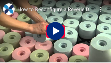 Hands reconfiguring Reverie DreamCell foam springs with a video play button overlay.
